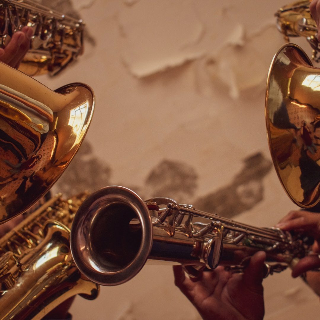 Flere brass instrumenter vises foran en hvit vegg. 