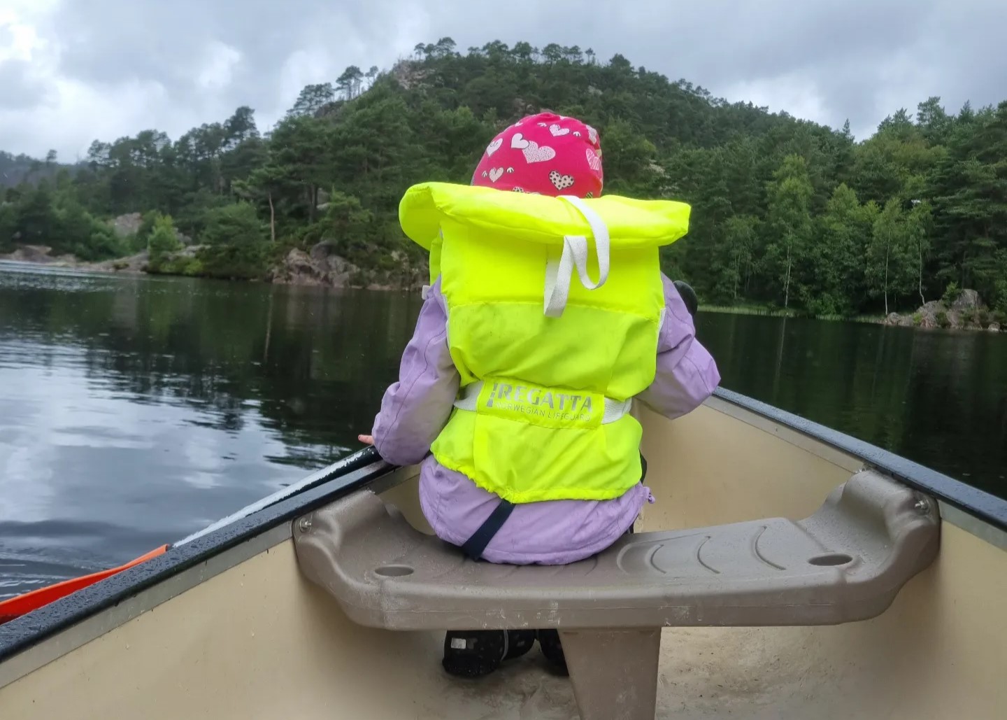 Kanoer og barn med flytevest på en  strand - sol og bading