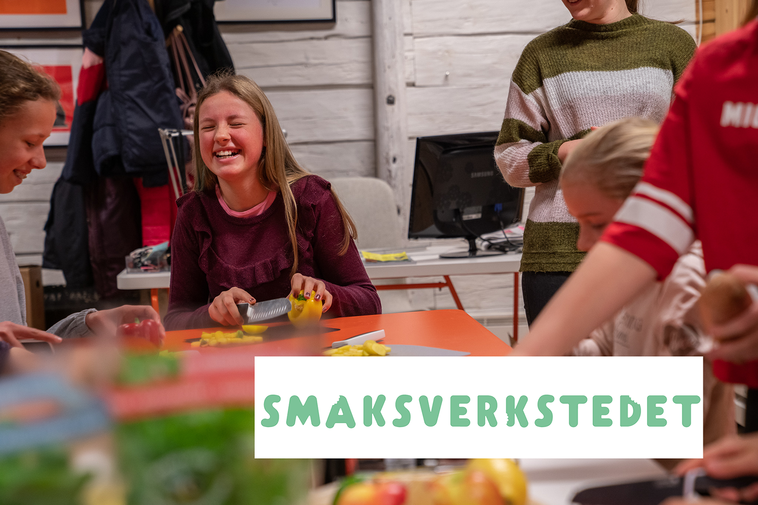 Smilende barn kutter grønnsaker.